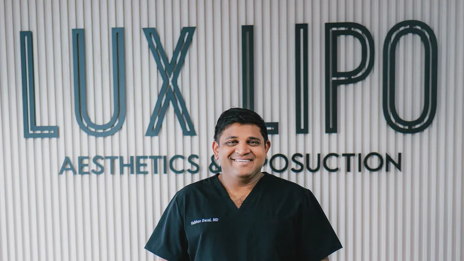 Dr. Vaibhav Desai, MD, at the Lux Lipo reception wall in Jonesboro